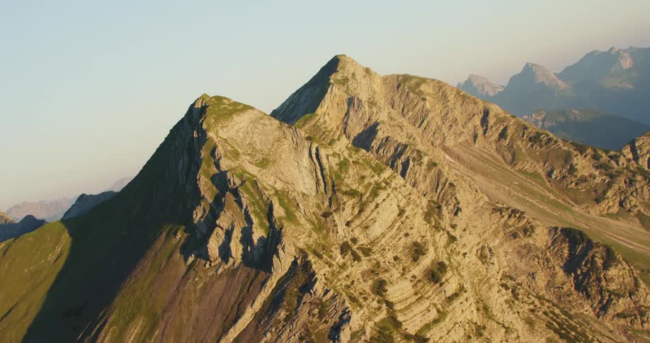A mountain range with peaks near the sky and clouds