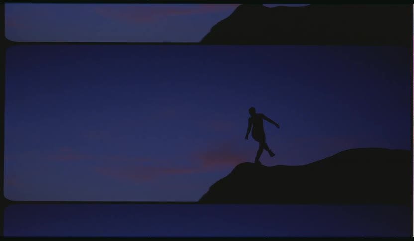 A silhouette of a person dancing and stretching on a cliff with the sky and clouds in the background
