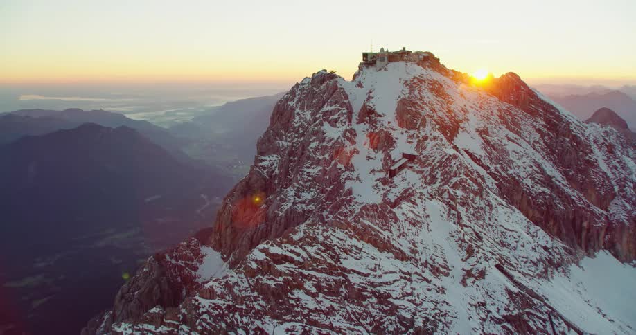 Sunlight shining over a snowy mountain range in the wilderness