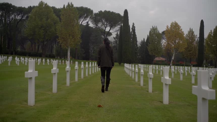 A woman walks in a veterans cemetery