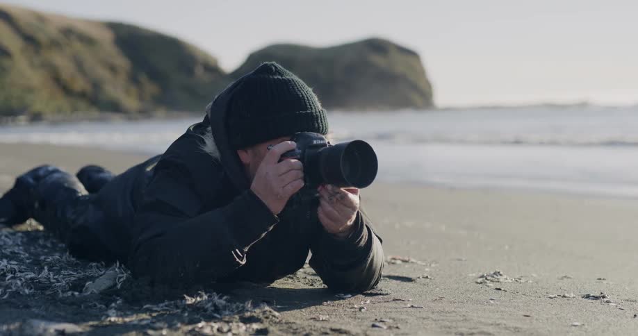 A man is taking pictures at the beach