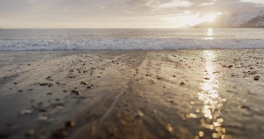 An ocean wave washing onto a beach in the winter