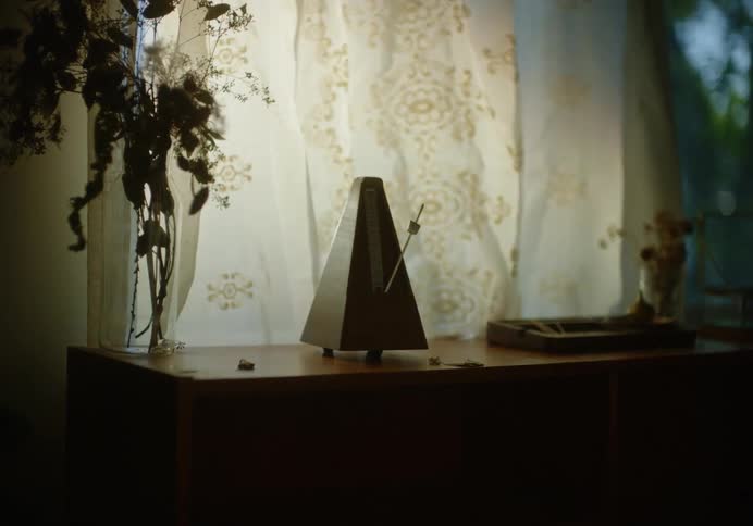Metronome ticking over a shelf in a room at home