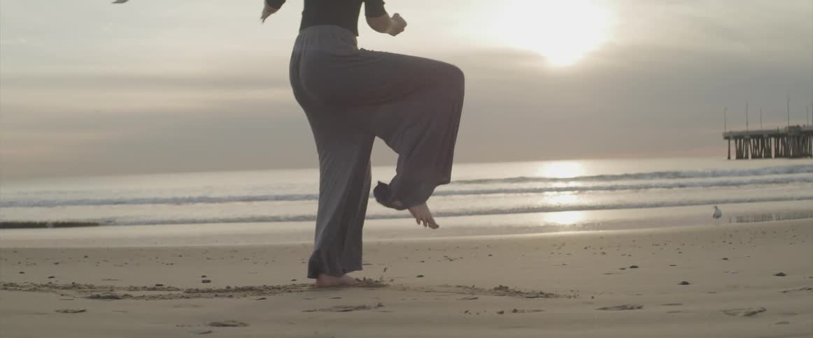 A woman is stretching at the beach