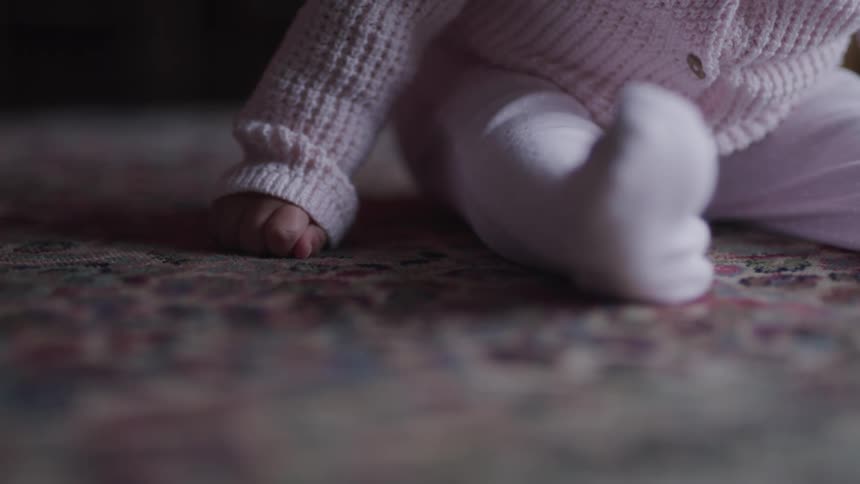 A baby sitting on the carpet