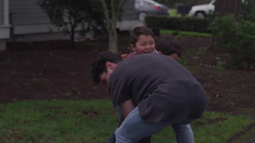 Father playing football with his two young boys outdoors