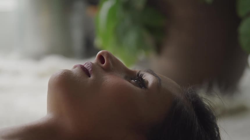 Woman with brown hair lies on the floor and looks at the ceiling