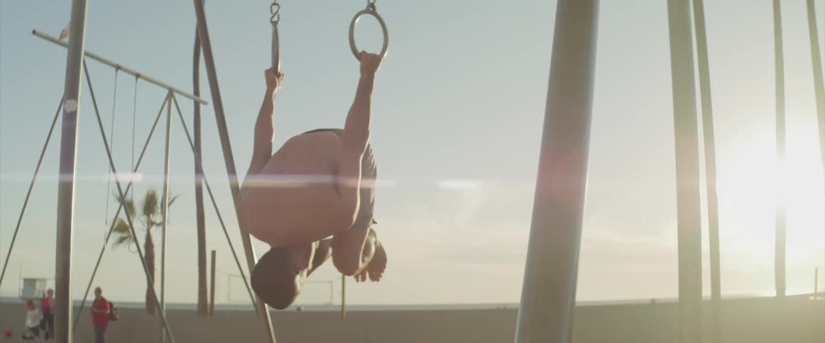 A man is exercising on the beach at dusk