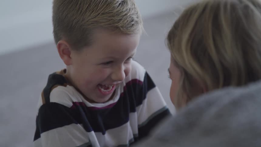 A little boys laughing with his mom