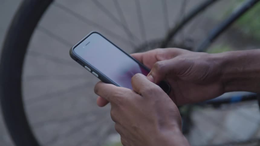 A man is texting on a cell phone outdoors