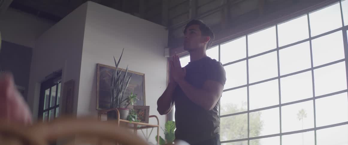 A man is doing yoga in his home