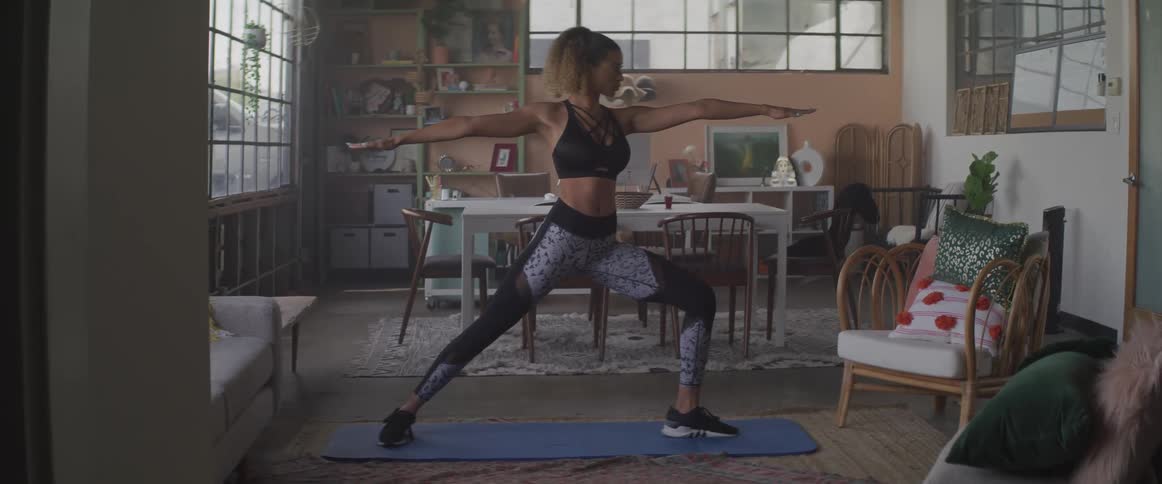 A woman practices yoga in the decorated living room of her home
