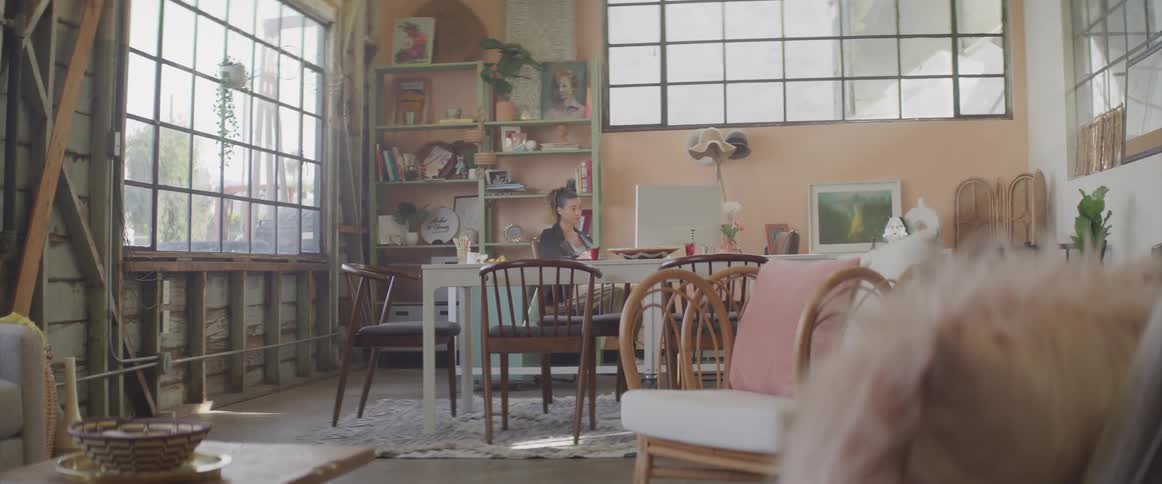 Woman works on a computer on the dining room at home