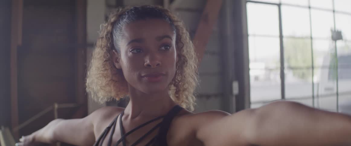 Young woman holds dance pose in front of window