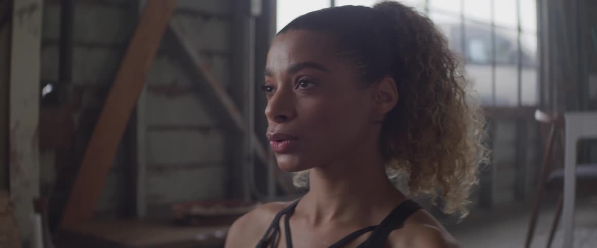 A young black woman exhales a long slow breath while indoors