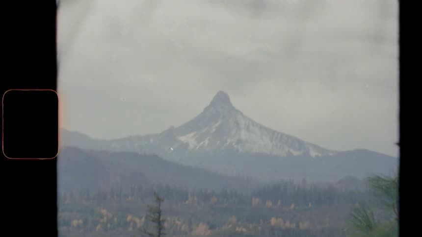 A snowy mountain peak in the distance on an overcast day