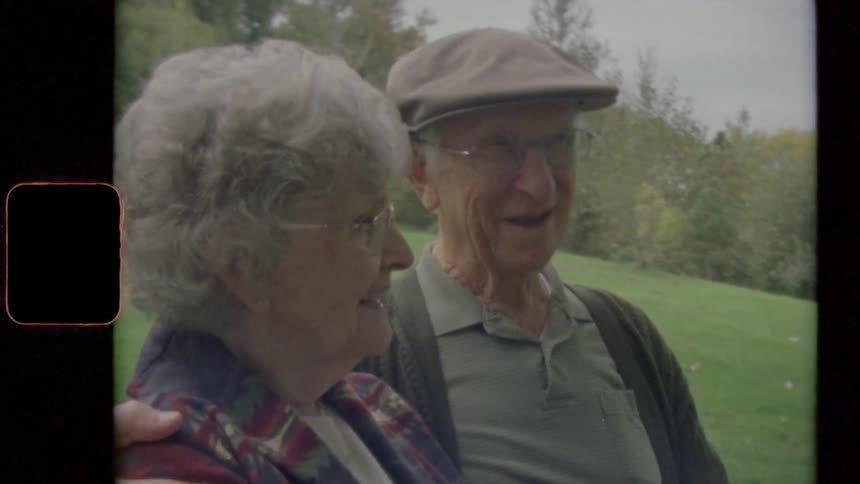 An elderly couple sit together looking relaxed and happy