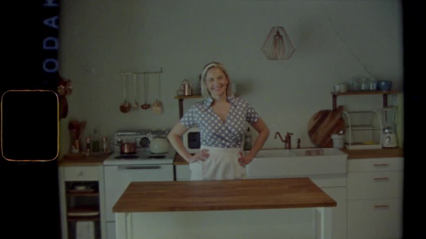 Vintage footage of a woman smiling in her kitchen