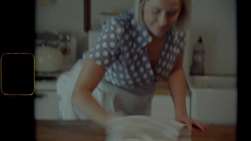 Vintage footage of a woman cleaning her kitchen