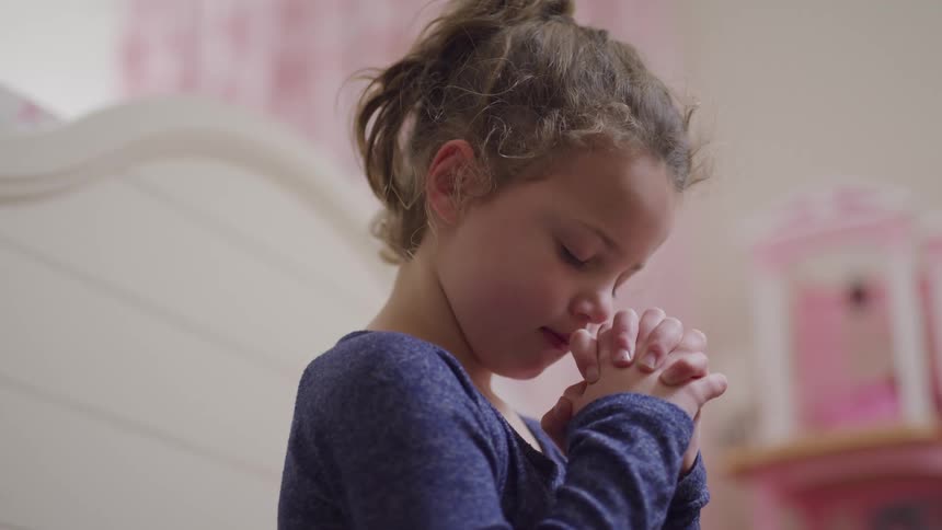 A female child standing and praying