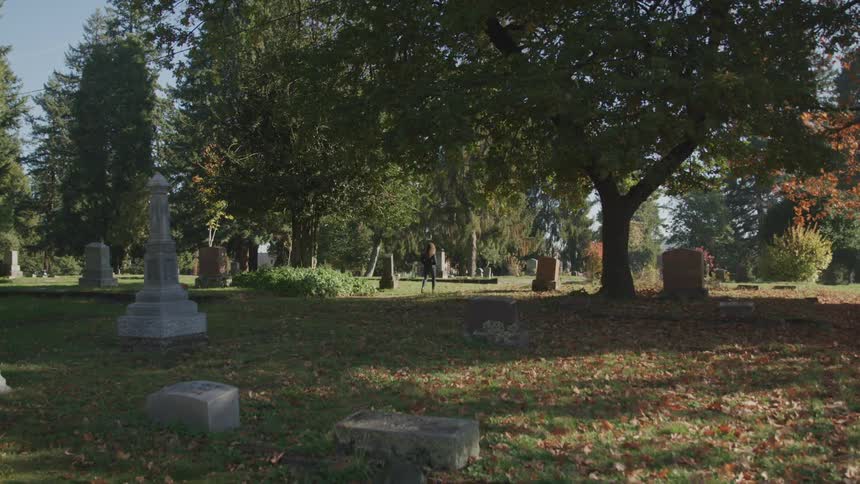 A woman walking through a cemetery