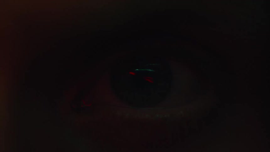 Close up of a mans eye as light flashes over it