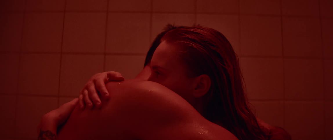 A man and woman hug in the bathroom