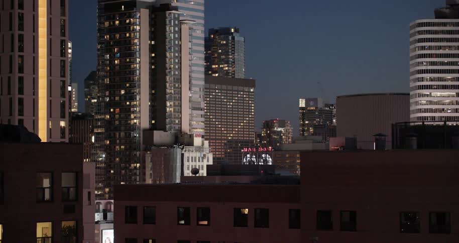 A city with a building that has its lights shaped like a heart that is surrounded by other buildings