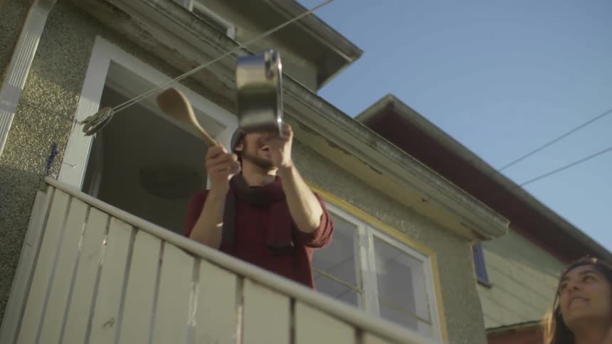 A man and woman are standing outside of their house