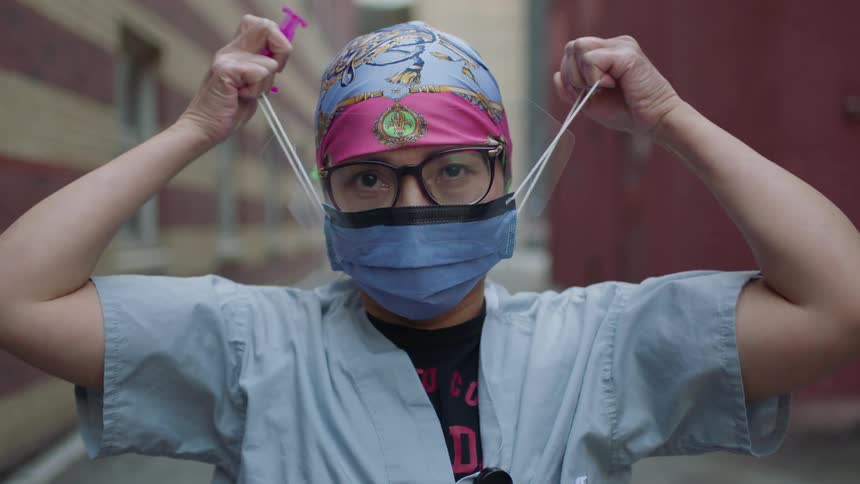 A nurse takes her mask off