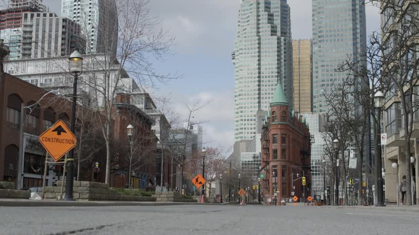 A woman walks down an empty city street