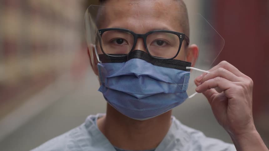 A man takes off his mask
