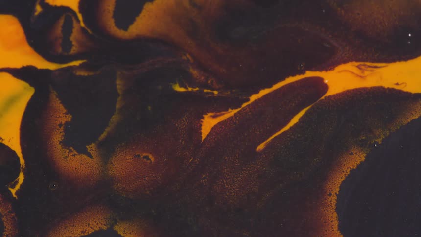 Yellow paint stands out against brown and black paints as they flow