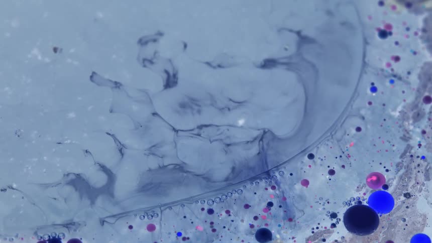 A purple liquid has other colors of liquid suspended within it as those colors move around
