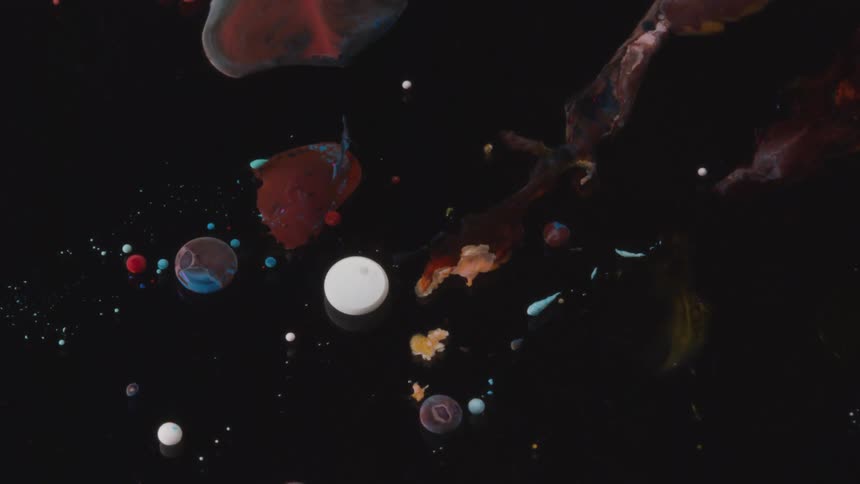 Different colored paints are used to create a design that looks like a melting solar system