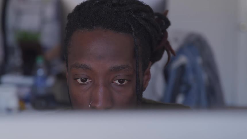 A young black man looking at a computer