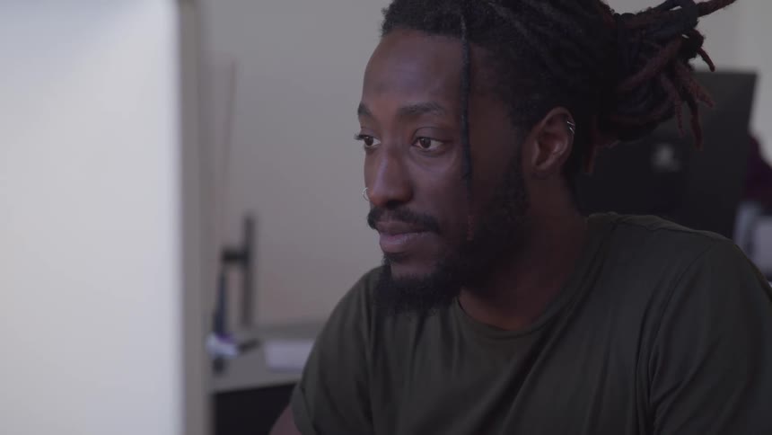 A man with dred locks is seated inside
