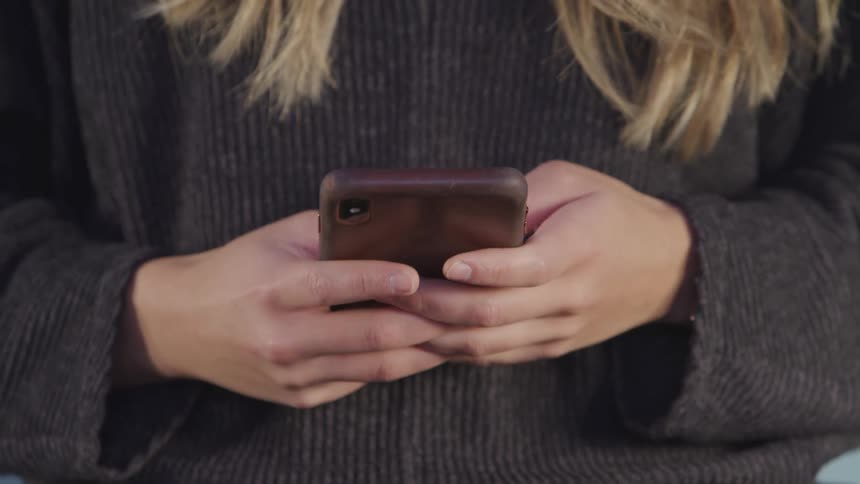 Woman texts rapidly on mobile phone then raises phone to make a call