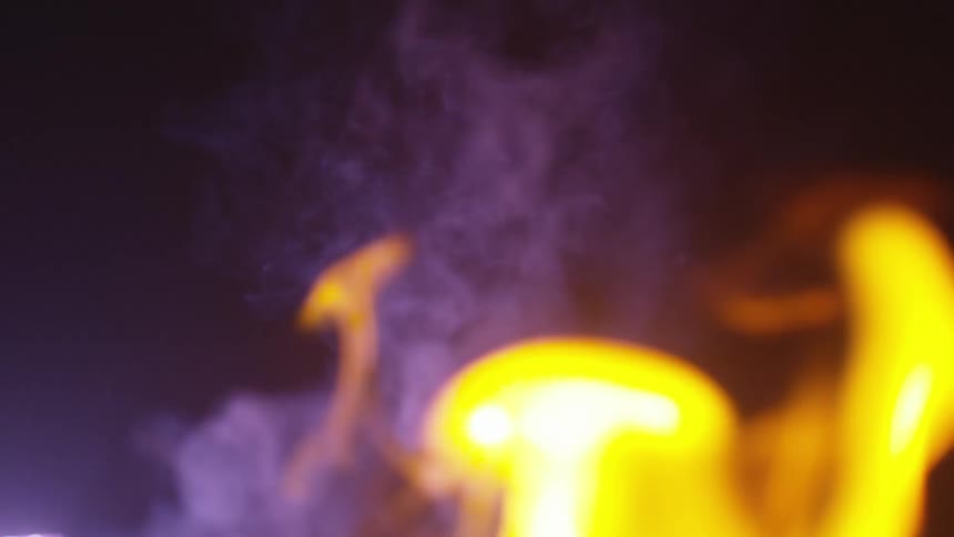 A fire is burning outdoors at night
