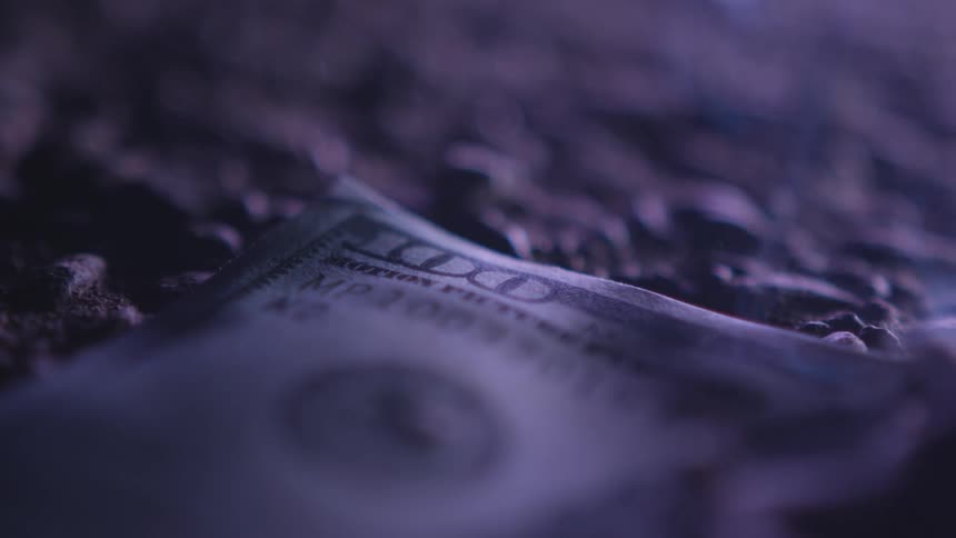 A hundred dollar bill on the ground with smoke light and shadow