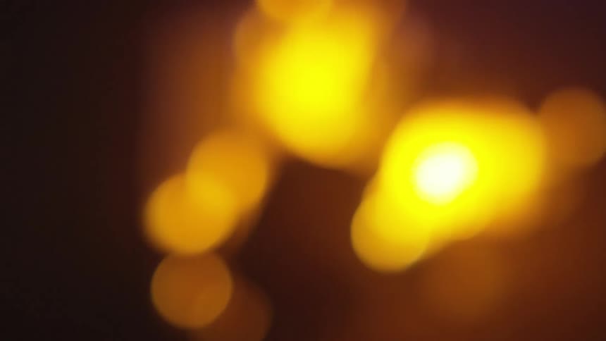 Glowing yellow lights or flames against a dark background