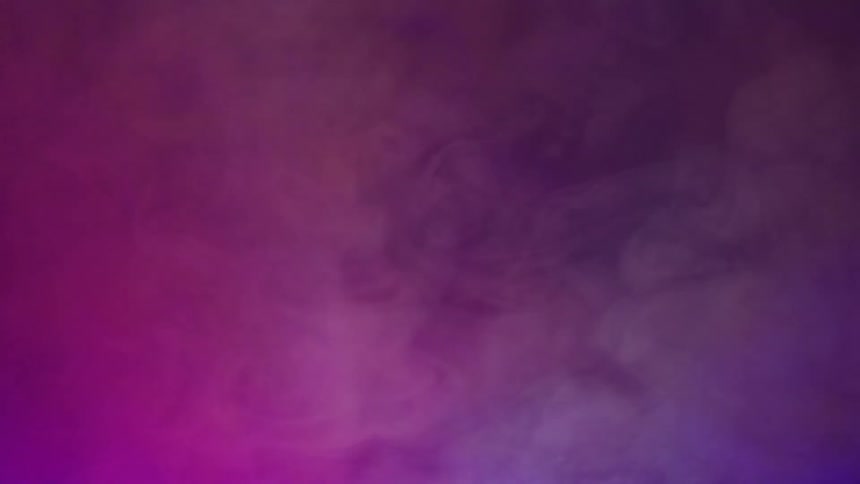 Red and purple lights reflecting in the fog on a dark room