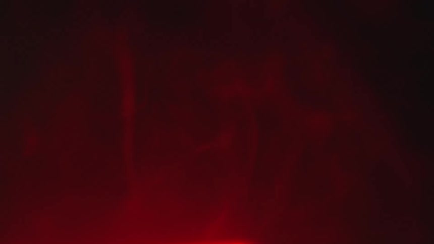 Cloudy red cloud rises against black background