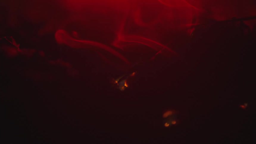 Light red smoke raises as small apertures glow yellow