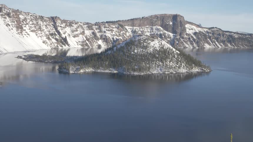 Aerial view of a lake and snow covered cliffs