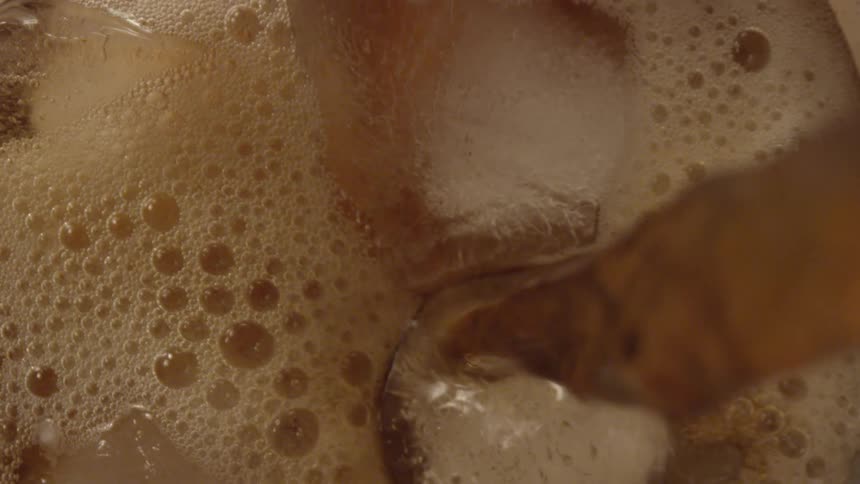 Liquid is being poured into a cup of ice