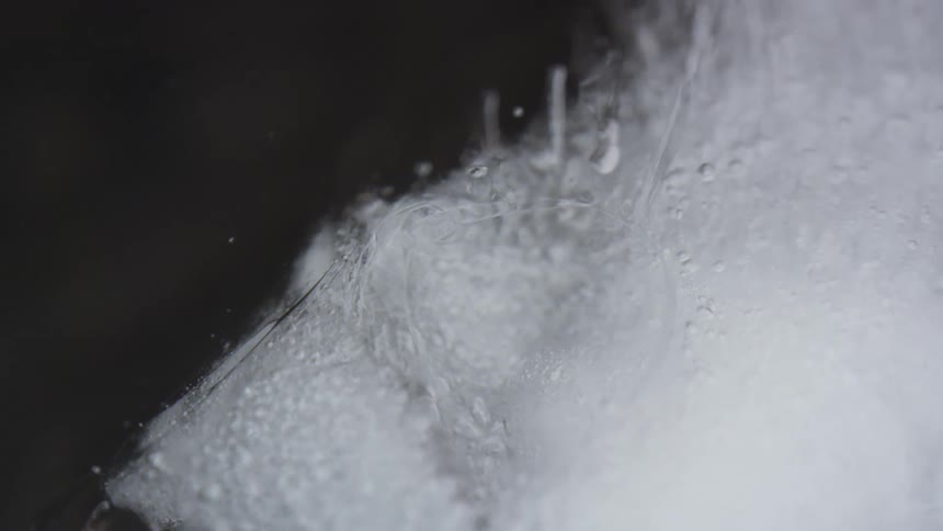 Ice floats on surface of water as bubbles rise