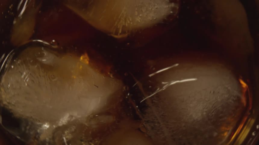 Ice and alcohol spin in a drinking glass as the glass is shaken