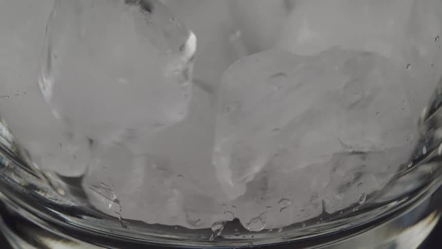 Close up of ice cubes falling into a glass