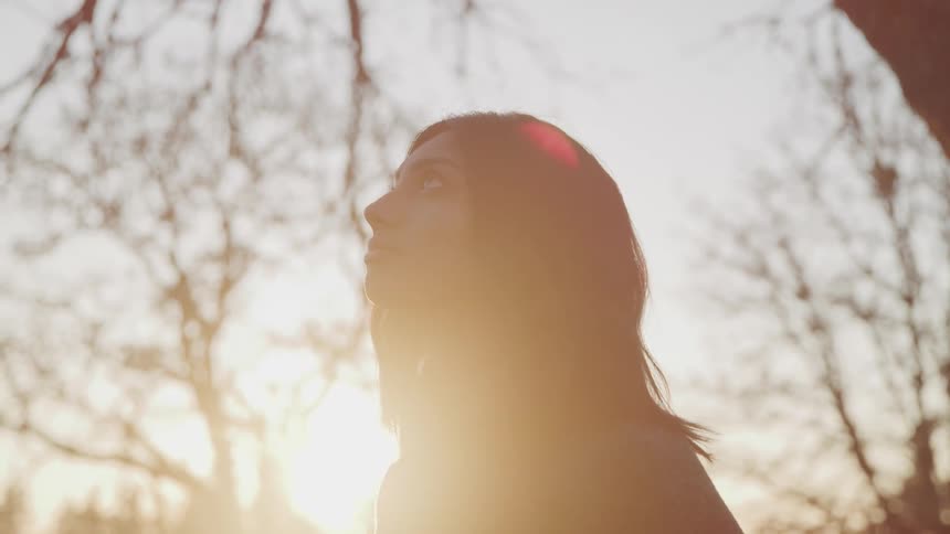 A woman is looking up at the sky